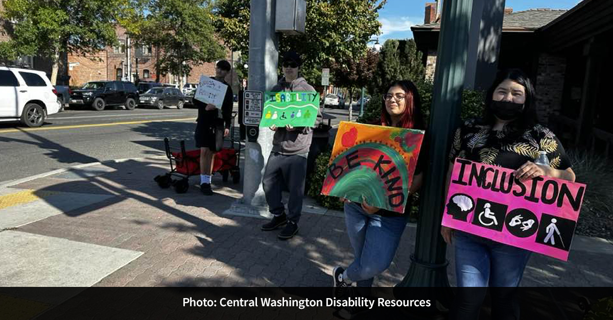 Four people holding signs advocating for disability rights.
